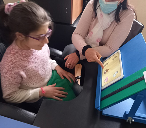 Alumna aprendiendo a usar los pictogramas en la tablet, apoyada por la educadora de Creática