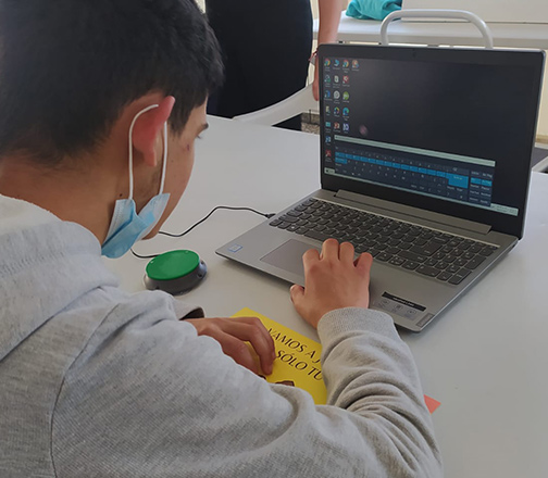 alumno en creática utilizando una laptop con mouse inclusivo