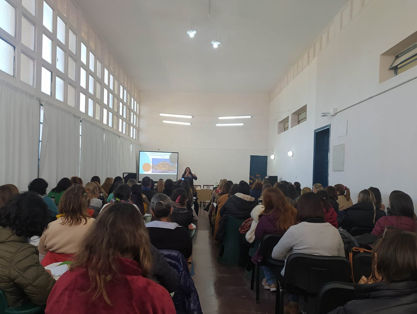 profesional de creástica dictando una charla en una institución educativa